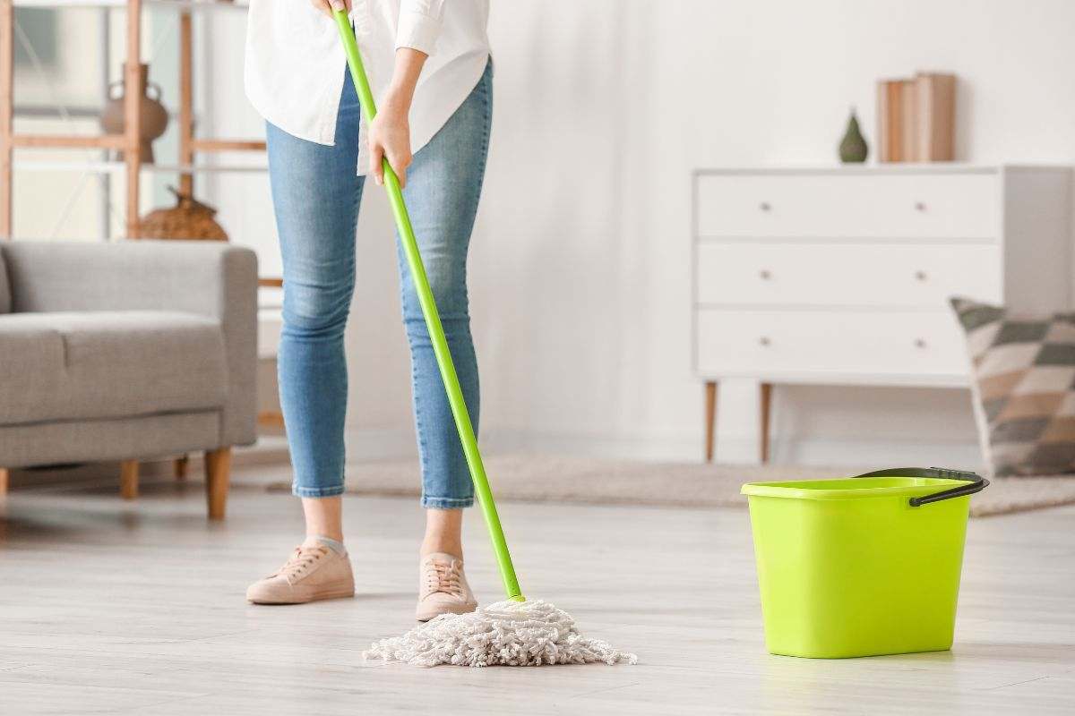 Donna lava il pavimento di casa