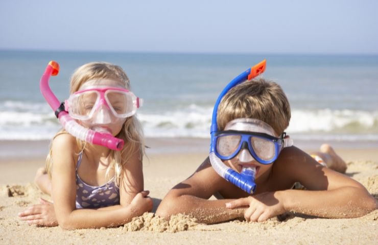 Due bambini giocano in spiaggia