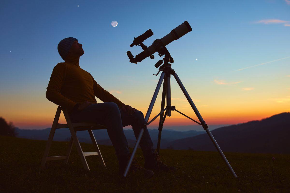 Uomo osserva il cielo con il telescopio