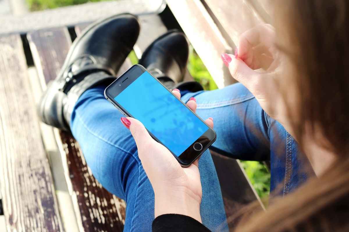 Una ragazza con uno smartphone in mano