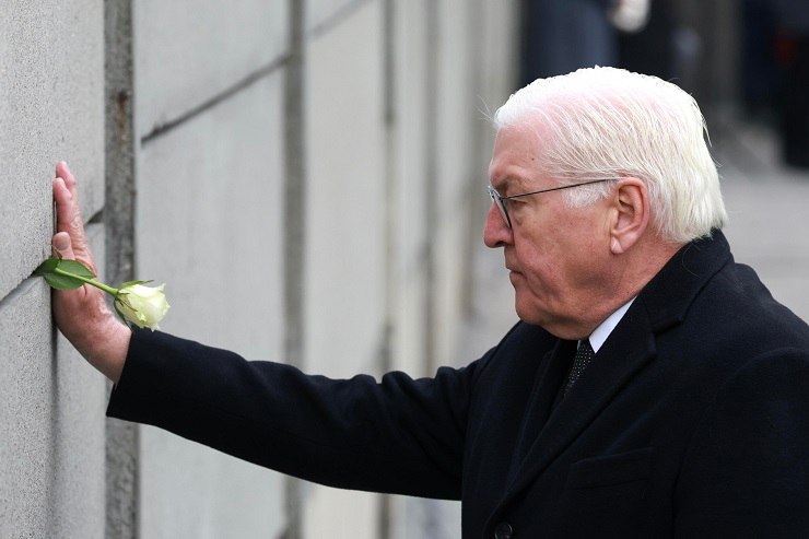 Frank-Walter Steinmeier inserisce una rosa nel muro di Berlino